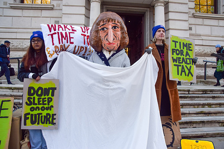 Activists from the group Green New Deal Rising stage a protest outside the Treasury ahead of the Budget, depicting Chancellor of the Exchequer Rachel Reeves asleep in bed and calling on her to 'wake up' and introduce a wealth tax.