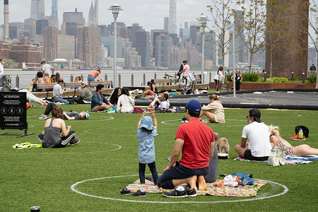 People relaxing with in the new social distancing circles at Domino Park in Brooklyn amid the coronavirus pandemic.
Governor Cuomo of New York announced earlier this week that the state’s beaches would open for Labor Day Weekend, however New York City beaches will still remain closed to bathing and gatherings, failure to comply would result in fencing to prevent people accessing them.