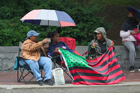 People hold an African American flag as they watch the Harrisburg Juneteenth parade.