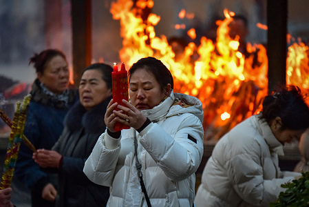 With her eyes tightly closed and hands clasping red candles, a woman pours her heart into prayer, surrounded by fellow worshippers at Zifu Chan Temple on Lunar New Year's Day. On the first day of the Lunar New Year, large numbers of people visit temples to burn incense and offer prayers for blessings, health, and good fortune. This long‑standing tradition is deeply rooted in Chinese folk culture and Buddhist customs, bringing a strong festive atmosphere to local communities.