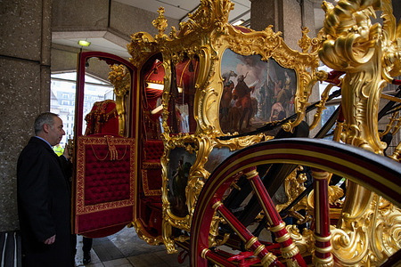 An usher opens the door to the Gold Coach before The Lady Mayors Show. The 697th Lord Mayor's Show marks the first "Lady Mayor's Show," with Dame Susan Langley DBE becoming the third woman to serve and adopting the title "Lady Mayor." The annual event dates back to 1215 and features over 7,000 participants, 200 horses, and several floats. The Lady Mayor travels a three-mile route to the Royal Courts of Justice in the State Coach.
