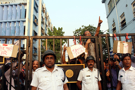 Doctors shout slogans behind the main gate under the protection of the police from the goons who tried to beat them during the strike.
The Students and Junior Doctors of NRS Medical College carrying on with a protest demanding better security following an incident of a Patient’s family badly beating up a Junior Doctor for alleged medical negligence. The strike begun on 10th June 2019 and More than 50 doctors shut the gates of the medical institution.