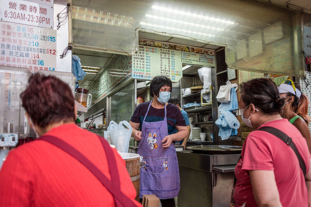 People wait outside a restaurant for take-away orders while wearing face masks as a preventive measure against the spread of Coronavirus (COVID-19).Hong Kong bans restaurant eat-in as it experiences third wave of coronavirus cases.