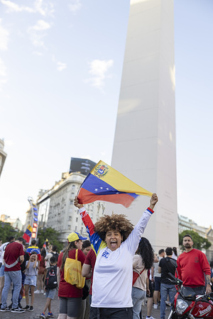 A young woman raises a Venezuelan flag during the demonstration. Hundreds of Venezuelan residents gathered at the Obelisk to celebrate the fall and capture of Nicolás Maduro. The demonstration was characterised by strong emotions, national flags and chants took place with a main gathering time of 5:00 p.m.