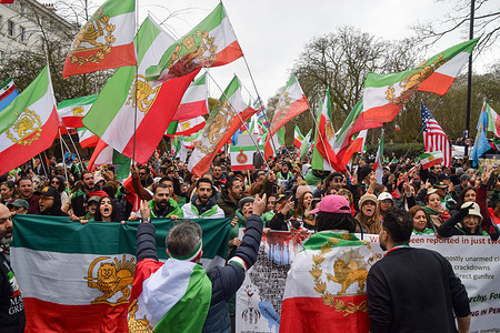 Pro-monarchy Iranians hold Iranian flags with the lion and sun symbol as they celebrate the death of Khamenei outside the Embassy of Iran and call for Reza Pahlavi to take over as King of Iran. Ayatollah Khamenei was killed in air strikes by USA and Israel.