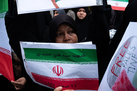 A protester holds an Iran national flag during the demonstration to mark the Al-Quds Day outside embassy of Israel in Bangkok. Hundreds of protesters gathered outside the embassy of Israel in Bangkok to protest against the war between USA-Israel and Iran and also mark the Al-Quds Day.