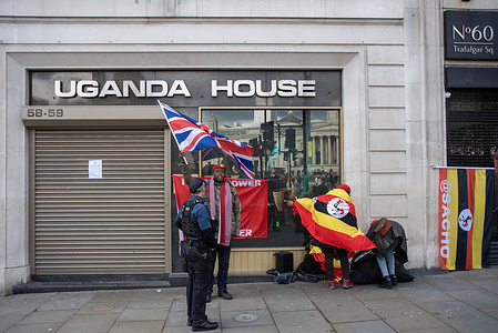 A police officer talks with one of the activists outside the Ugandan High Commission. Three activists from the People Power, Our Power movement protested outside the Uganda High Commission on the Trafalgar Square in London. The People Power, Our Power movement is a resistance pressure group in Uganda. It is led by Bobi Wine. The members of the movement oppose the ruling party called National Resistance Movement 40 years dictatorship and its President Yoweri Kaguta Museveni.