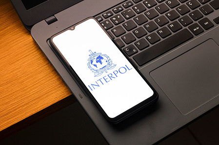 In this photo illustration, the International Criminal Police Organization (Interpol) logo is seen displayed on a smartphone screen.