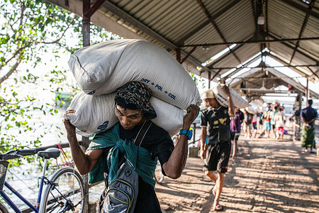 Workers are seen carrying bags of rice at the Yangon river port.
Two days after the Myanmar's military detained the country's de facto leader Aung San Suu Kyi and the country's president in a coup, life seems to be going on in Myanmar despite the anxiety and uncertainty over the future.