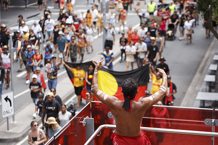An indigenous protester applauds the crowd as they march towards Musgrave Park during the rally.
Indigenous Yuggera and Turrbal people organized a rally in Brisbane (Meanjin in the indigenous language) to protest the Australia Day holiday on the 26th January, a date seen as synonymous with the beginning of British colonial rule and oppression of Aboriginal people. They called for a change to the date and discussed themes such as fighting against racial injustice and remembrance of the Stolen Generations and Aboriginal sovereignty.