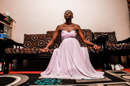 A 23-Year-Old model Risper Atieno poses in her room in the Kibera Slum. The young Kenyan youths are driven into a competency of having their own homes away from their parents where they, most importantly, learn to tackle life through different challenges. The competition to have the best-decorated rooms filled with different designer outfits is one way of avoiding daily difficulties such as drug abuse, teenage pregnancies, early marriages, and negative judgments from locals. To most young youths having a home is the start of a new life, and it comes with many responsibilities. Unauthorized housing is the most lucrative investment in Kenya today. Therefore for one to have a house with landlords renting rooms to let at Ksh 1,500 ($ 12) to Ksh 5000 ($ 40) a month, that is almost too hard to pay for most youths with low-income jobs and therefore needs an extra effort to raise their sources of income.