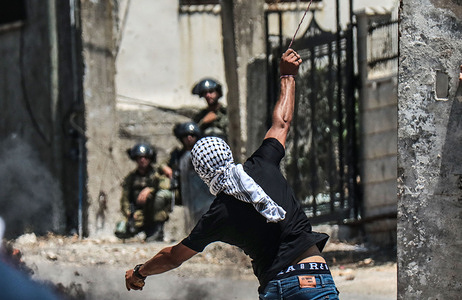 A Palestinian protester throws stones towards Israeli soldiers during the demonstration against Israeli settlements in the village of Kafr Qaddoum near the West Bank city of Nablus.