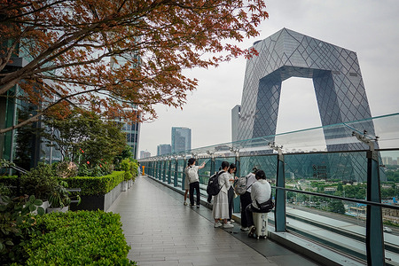 People gather on a terrace in Beijing's CBD near the CCTV Headquarters building. China's gross domestic product expanded by 5.3 percent to 66.05 trillion yuan in the first half of 2025, the National Bureau of Statistics said on Tuesday.