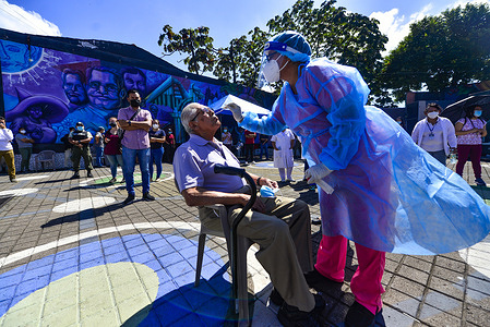 A health worker collects a nasal sample during a COVID-19 testing operation at the culture Plaza as the country registers a spike in daily confirmed cases.