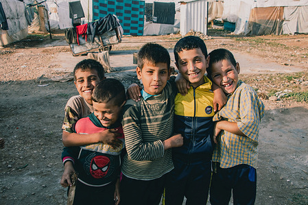 Syrian boys pose for a photo before playing together in the camp. Around 50 Syrian families live in an informal refugee camp in Akkar, north of Lebanon. Since children in the camp are rarely provided with education, they will work with their family household or in the field.