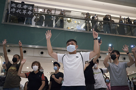 Protesters gesturing the "Five demands, not one less" protest motto during the demonstration.
Hundreds of protesters gathered in the New Town Plaza shopping mall in Sha Tin to mark the one-year anniversary of major clashes between police and pro-democracy demonstrators.