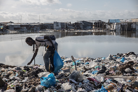 A man sifts through rubbish looking for things he can sell. West Point is Liberia's largest urban slum, home to a community of roughly 75,000 people.