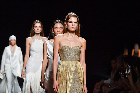 Models walk the runway wearing a design by Claro Couture during Mercedes-Benz Fashion Week de Madrid in IFERMA.