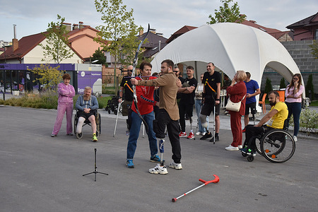 A trainer helps an amputee Ukrainian soldier shoot a bow during an archery master class. Ukrainian soldiers who suffered serious injuries, such as amputations, during the Russian-Ukrainian war, are currently undergoing rehabilitation at the Superhumans Center. At this facility, they receive custom-made prostheses to help them adapt to their new lives. Additionally, they participate in psychological rehabilitation activities, like archery master classes.