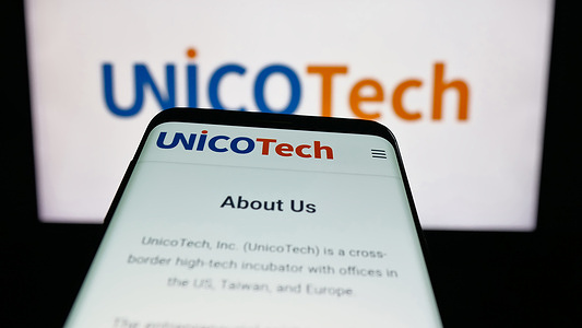 In this photo illustration, a mobile phone with the website of AI investment company UnicoTech Inc. is seen on screen in front of logo.