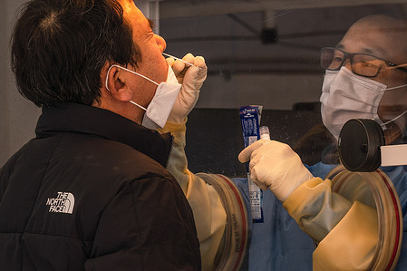 A member of medical staff wearing a personal protective equipment suit (PPE) takes a swab sample from a man at a temporary COVID-19 testing site in Seoul Square.
South Korea reached 1,097 new confirmed COVID19 cases, which is the highest record since the virus broke out in South Korea.