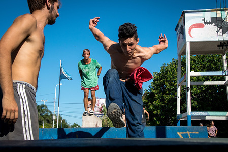 Three 'traceurs' the preferred term for a practitioner of parkour, work on their techniques during a parkour community meeting.
In March of 2018, parkour practitioners (known as 'traceurs') from Buenos Aires and the surrounding area came together in a community, 'jam'. This meeting gave talented urban athletes a chance to support each other, work on technique, and celebrate each other's efforts.