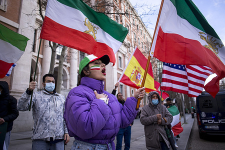 A woman from the Iranian community in Madrid, with an Iranian flag painted on her face and another in her hand, shouts during a protest in front of the United States Embassy in Madrid, demonstrators demanded an end to the violence and repression by the Islamic Republic regime in Iran.