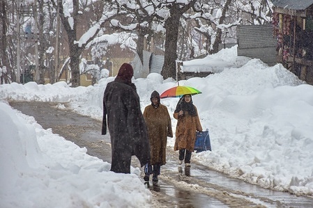 Commuters walk along the snow covered road during snowfall in Budgam, about 70kms from Srinagar. Fresh snowfall across Kashmir disrupted life across the valley, forcing the closure of the Jammu–Srinagar national highway, the only all-weather road linking the Kashmir Valley with the rest of the country and cancellation of all flights at Srinagar airport, leaving hundreds of tourists stranded.