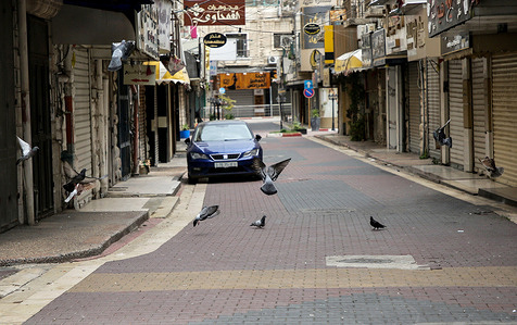 Pigeons fly amidst closed shops in the market of Nablus in the West Bank during a general strike in areas under Palestinian Authority control.