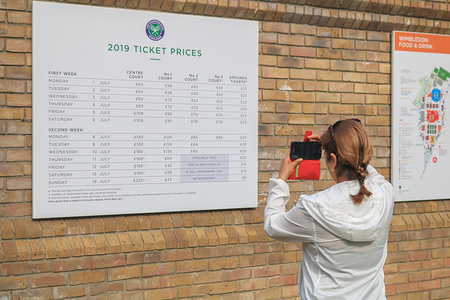 A lady takes photos of the Ticket prices posted on a board outside the Main courts of All England Lawn tennis Club (AELTC) before the start of the 2019 Wimbledon Championships due to start on 1 July.