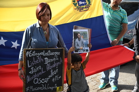 Family members of the victims seen speaking outside the morgue with in front of a Venezuelan flag.
For the fifth consecutive day, relatives of Oscar Perez, Police Inspector Gone Rogue, along with relatives of their comrades killed last Monday, January 15, by police forces of the Nicolas Maduro government gather in front of the morgue. The morgue still refuse to release the bodies as the government refuse to assign a military prosecutor to the case. The Attorney General of the Republic still keeps silence on this case.