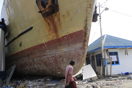 A man seen walking next to a stranded ship at the site where the earthquake happened.
A deadly earthquake measuring 7.5 magnitude and a tsunami wave destroyed the city of Palu and much of the area in Central Sulawesi. The death toll was 2088, around 5000 people were seriously injured and some 62,000 people were displaced.