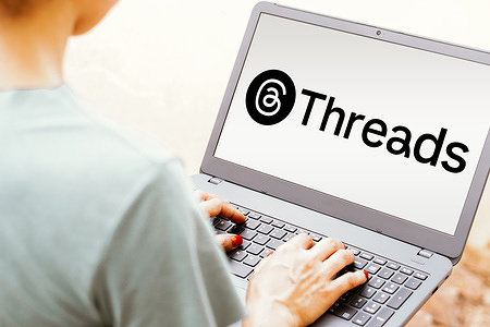 In this photo illustration, the Threads logo is seen displayed on a laptop screen.