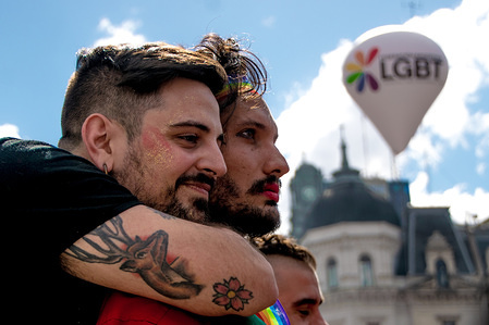Looking at the crowd below, a young couple embraces each other with an LGBT balloon and iconic landmarks in the background. Thousands of pride supporters marched from Plaza de Mayo to Congreso de la Nación during the city's 26th annual Marcha del Orgullo Gay (gay pride parade).