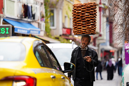A street vendor selling simit walks along a street in the Balat neighborhood of the Fatih district in Istanbul.