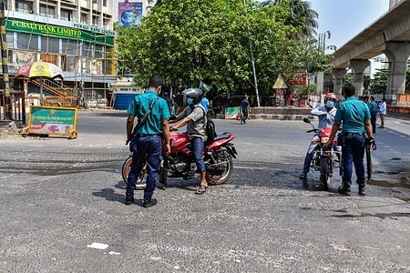 Bangladeshi police officers stop a motorist at a checkpoint as Bangladesh authorities enforce a strict lockdown to combat the spread of the Covid-19 coronavirus in Dhaka.