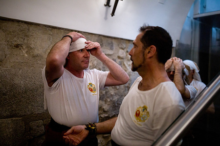 Members of the brotherhood prepare the carrying frame on their heads inside the church during the procession of the Holy Christ of the Three Falls from the Royal Parish Church of Santiago and San Juan Bautista, which wound through the streets of Madrid on Holy Wednesday.