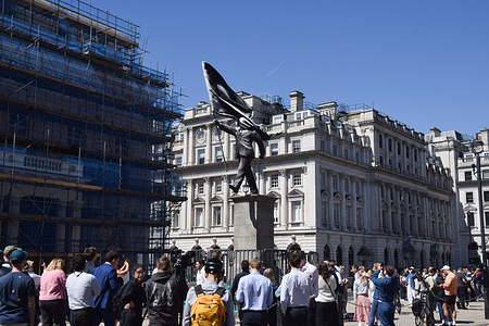 Crowds gather as a mysterious statue depicting a man holding a flag which covers his face, and signed 'Banksy' at the base of the plinth, appears in Waterloo Place in Central London. It has not yet been officially confirmed if Banksy is behind this latest artwork.