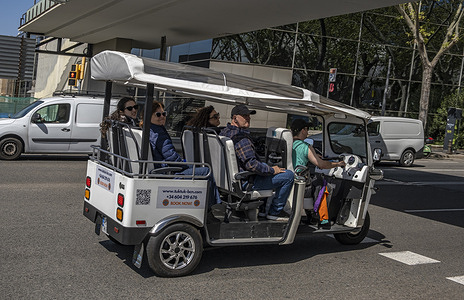 An electric motorized tourist car is seen making its rapid tour up Montjuïc mountain. Montjuïc mountain is one of Barcelona's key tourist destinations. Its concentration of green spaces, water features, and museums makes it a must-see for visitors. The esplanade in front of the National Art Museum of Catalonia (MNAC) is a hub of activity.