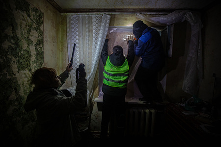 A volunteer from the Dobrobat collective places a plastic sheet over the window of a neighbor who has suffered an attack by Russian drones in Sumy. The Russian army attacked Sumy several times with drones. Part of the city was left without electricity or water due to the attacks on energy infrastructure. One of the drones hit a nearby residential building and the explosion shattered the windows of several apartments.