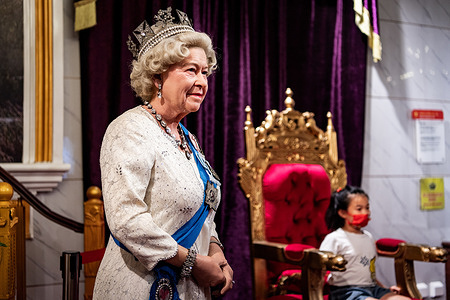 A kid poses next to a wax sculpture of Queen Elizabeth II at Wuhan Madame Tussauds wax museum. Queen Elizabeth II, the longest-serving monarch in British history and an icon instantly recognisable to billions of people around the world, died at her Scottish Highland retreat on September 8 at the age of 96.