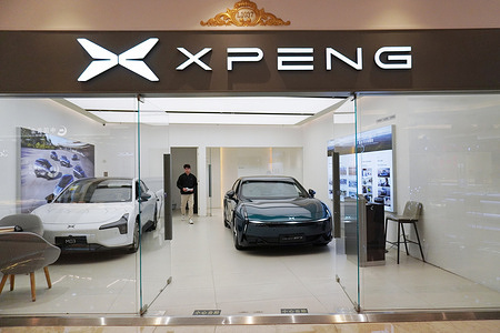 XPENG's showroom at Jiangnan Global Harbor displays two XPENG electric cars behind glass, with a staff member inside.