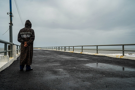 A soldier guards an entry to the port of La Libertad during the onset of the Storm Pilar. El Salvadoran government released a national state of emergency due to Storm Pilar. According to the US National Hurricane Center, Storm Pilar brought heavy rains to EL Salvador. They informed the public that heavy rains would produce flash and urban flooding and mudslides in higher terrain areas.