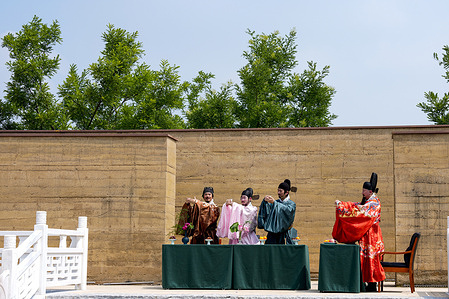 Performers seen performing a traditional costume and etiquette live show at the "Canal Fashion Show - Summer Gathering" stunning the audience at the Lu County Ancient City Ruins Park.