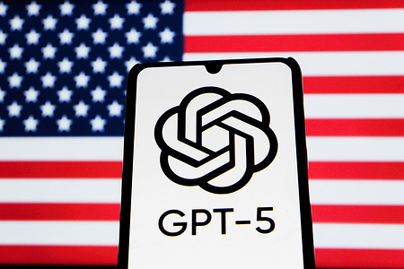 In this photo illustration, a GPT-5 logo is seen displayed on a smartphone with a blurred Flag Of America in the background.