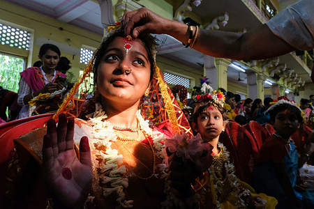 A young girl is seen posing for a photograph before the Kumari Puja at Adyapith temple on the outskirts of Kolkata. More than 2,000 young girls participate in the 'Kumari Puja' on the occasion of Basanti Durga Puja at Adyapith Temple on the outskirts of Kolkata. 'Kumari' describes a young girl aged of 1 to 16, who is worshipped during the transition of Ashtami and Navami tithi of Basanti Puja.