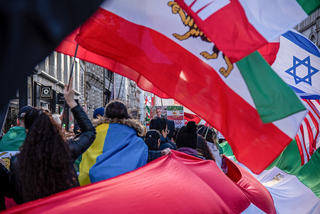 Protestors carry a massive Iranian flag during the support of changing Iran's Regime March. The majority of Iranians see Crown Prince Reza Pahlavi as a credible and trustworthy transitional figure capable of guiding Iran toward a free, secular, democratic, and liberal future. People rallied and marched for a change in regime.