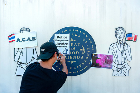 Anti-APEC demonstrator from "Citizens Stop Apec 2022 Coalition " installs a placard that says "Police Everywhere Justice Nowhere!" during the demonstration at U.S. Consulate General in Chiang Mai. The "Citizens Stop Apec 2022 Coalition" demanded that the U.S. government, as one of 21 APEC Members, take responsibility for the human rights abuses commited at the rallies which were violently dispersed by riot police on 18 November at the APEC 2022 summit in Bangkok. There were 25 people arrested, and at least 31 people were injured, including Mr. Phayu Boonsophon, a protester who was shot by a rubber bullet and lost his right eye.