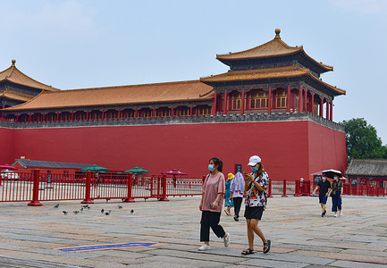 People wearing facemasks as a precaution against the spread of covid-19 seen walking past the Meridian Gate of the Forbidden City in Beijing.