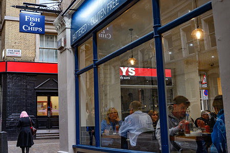 A customers seen at a traditional British fish and chip shop restaurant on the south bank of the River Thames.
